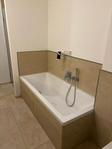 a bath tub with a shower in a bathroom at 2 Rooms Shanghaiallee Appartment in Hamburg