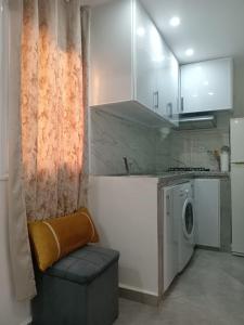 una cucina con lavatrice e sedia di Taghazout Flat a Taghazout Altre 11 foto