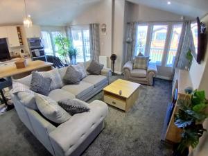 a living room with couches and a table and windows at Sea Breeze, Vintage 90, Luxury 2 bed Lodge, Skegness, 2 friendly - East Coast Holidays in Winthorpe