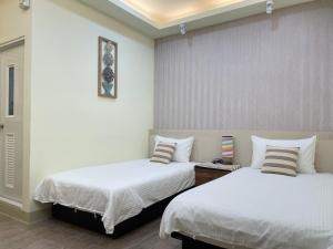 Una cama o camas en una habitación de Yu Shou Hao Hsien Guesthouse