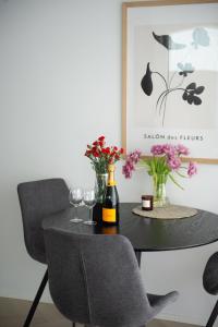 a dining room table with two chairs and wine glasses at Neliapila Cozy Apartment in Kokkola +1 photo