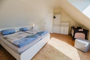ein Schlafzimmer mit einem Bett mit blauen Kissen darauf in der Unterkunft Landhaus Ferienwohnung 2, Bauernhof Hopp Vadersdorf in Fehmarn