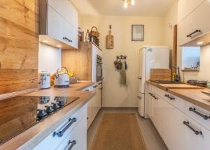 a kitchen with white cabinets and a refrigerator at Wohlfühl Oase mit Sauna vor den Toren Berlins in Nauen