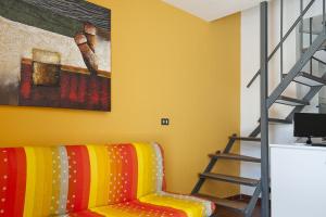 a living room with a colorful couch and a ladder at Pets under the Sun in Alberobello