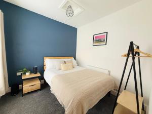 a bedroom with a bed and a blue wall at 4 Bedroom House in Port Talbot with Parking, Near M4, Ideal for Contractors in Port Talbot