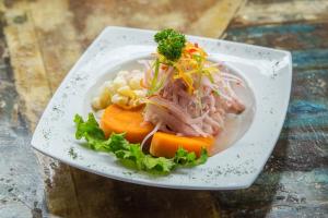 a plate of food with meat and vegetables on it at Hostal Brisas del Mar in Punta Negra