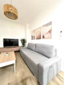 Una sala de estar con un sofá y un televisor de pantalla plana. en Apartamento centro Punta Umbría, en Punta Umbría
