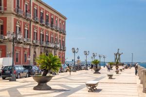 a city street with buildings and people walking on the sidewalk at La Grande Bellezza in Taranto