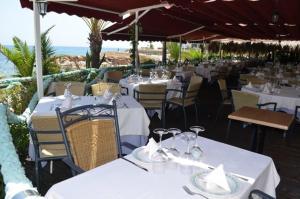 ein Restaurant mit weißen Tischen und Stühlen und Meerblick in der Unterkunft Vista Mar Torrevieja in Torrevieja