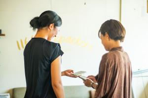 two women standing next to each other in a room at 1166 Backpackers in Nagano