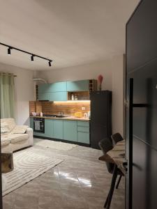 a kitchen with blue cabinets and a table and chairs at Hey Apartment 1 in Hamallë