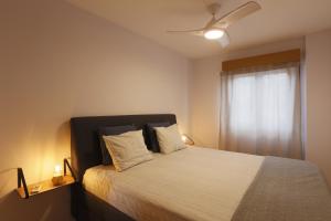 ein Schlafzimmer mit einem Bett mit weißer Bettwäsche und einem Fenster in der Unterkunft Vivienda Vacacional Avioli in Tazacorte