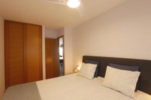 ein Schlafzimmer mit einem Bett mit weißen Laken und Kissen in der Unterkunft Vivienda Vacacional Avioli in Tazacorte