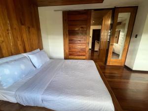 a large bed in a bedroom with a wooden floor at 1BR Northpoint Condo Free Airport pick up for 3 nights stay or more in Cabaguio