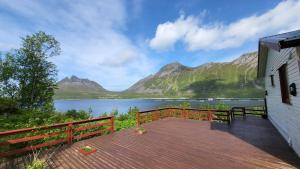 a deck with a view of a lake and mountains at Rifi Senja House in Senja