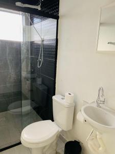 a bathroom with a toilet and a shower and a sink at Pousada Rancho Bananas Felizes in Miracatu +23 photos