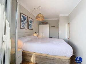 Un dormitorio con una gran cama blanca y un espejo. en Can Alfredo, Apartamento Cala en Bosch con piscina, terraza y jardín privado, en Cala'n Bosch 22 fotos más