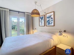 Un dormitorio con una cama grande y una ventana en Can Alfredo, Apartamento Cala en Bosch con piscina, terraza y jardín privado, en Cala'n Bosch