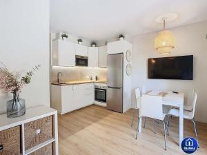 Una pequeña cocina con una mesa y un refrigerador. en Can Alfredo, Apartamento Cala en Bosch con piscina, terraza y jardín privado, en Cala'n Bosch