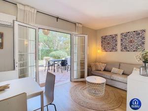 una sala de estar con un sofá y una mesa en Can Alfredo, Apartamento Cala en Bosch con piscina, terraza y jardín privado, en Cala'n Bosch