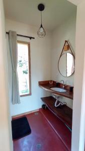 a bathroom with a sink and a mirror at Chalé Das Quaresmeiras in Aiuruoca +7 photos