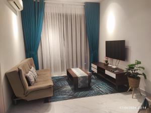 a living room with a television and a chair and a table at Troika Residence Studio, Kota Bharu by MYRAH in Kota Bharu