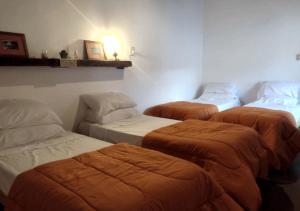 a room with three beds in a room at El Rincón de las Palmas in Cafayate