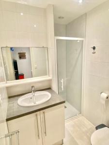a white bathroom with a sink and a shower at ÎLE D OLÉRON Charmante Maison Oléronaise & Piscine chauffée in Saint-Georges-dʼOléron