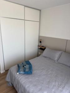 ein Schlafzimmer mit einem Bett mit einer blauen Tasche darauf in der Unterkunft Departamento de 1 dormítorio más sofá cama en living in Marcos Juárez