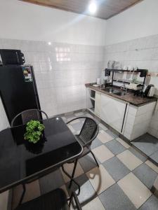 a small kitchen with a black table and a counter at hospedaje temporario in La Quiaca