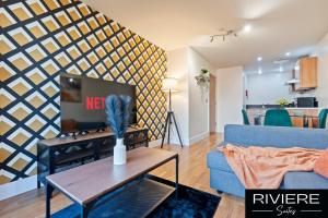 a living room with a blue couch and a table at Cosy Apartment-City Centre-Parking-Sleeps 5 in Birmingham