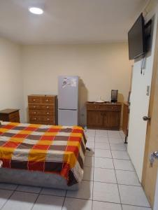 a bedroom with a bed and a refrigerator at Habitación H in Santiago
