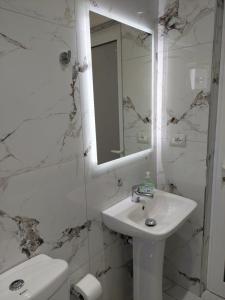a white bathroom with a sink and a mirror at HILLSIDE Guesthouse in Ksamil +20 photos