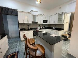 a kitchen with white cabinets and a black counter top at Neth Villa! in Negombo