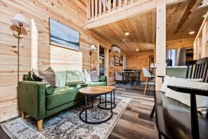 a living room with a green couch and a table at Holidays in Cozy Mountain Cabin - Near Dollywood, Parkway, Biggest Zipline - Hot Tub, Games, Hammock in Sevierville