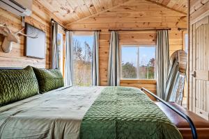 a bedroom with a large bed with a large window at Holidays in Cozy Mountain Cabin - Near Dollywood, Parkway, Biggest Zipline - Hot Tub, Games, Hammock in Sevierville +40 photos