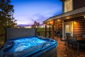 a hot tub on the deck of a house at Holidays in Cozy Mountain Cabin - Near Dollywood, Parkway, Biggest Zipline - Hot Tub, Games, Hammock in Sevierville