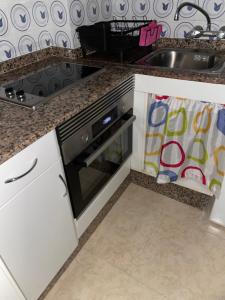 een keuken met een fornuis en een spoelbak bij Céntrico Hospedaje en Vigo in Vigo