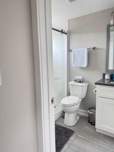 a white bathroom with a toilet and a shower at Horizon Hideaway in Mobile