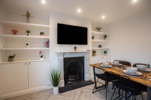 a living room with a fireplace and a television on a wall at Modern Bromley 2 Bed apartment great location parking available in Grove Park
