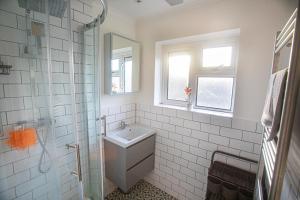 a white bathroom with a sink and a shower at Modern Bromley 2 Bed apartment great location parking available in Grove Park