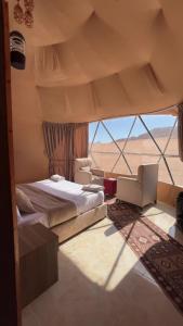 a bedroom with a bed and a view of the desert at Wadi Rum Rose Luxury camp in Wadi Rum +119 photos