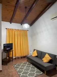 a living room with a couch and a yellow curtain at Santa Teresita in Concepción del Uruguay