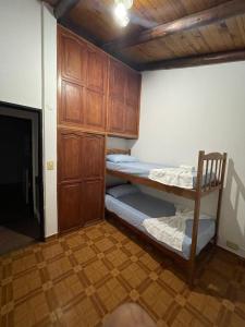 a room with two bunk beds and a wooden cabinet at Santa Teresita in Concepción del Uruguay