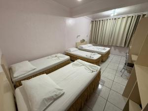 ブルメナウにあるOasis Chartouni Hotelの部屋に3つのベッドがあるグループ