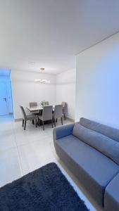 a living room with a blue couch and a table at Quarto São João - familiar in Campina Grande +6 photos