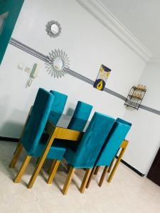four blue chairs in a room with a wall at Khurtis 225 in Abidjan