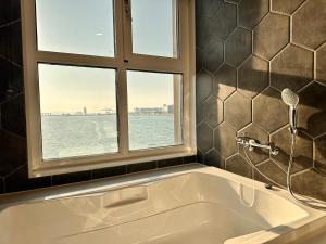 a bath tub in a bathroom with a window at Restia Incheon Bay Hotel in Incheon
