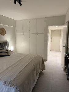 a bedroom with a large bed with white cabinets at Departamento Mendoza Centro remodelado a nuevo in Mendoza