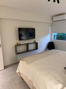 a bedroom with a bed and a tv on the wall at Departamento Mendoza Centro remodelado a nuevo in Mendoza